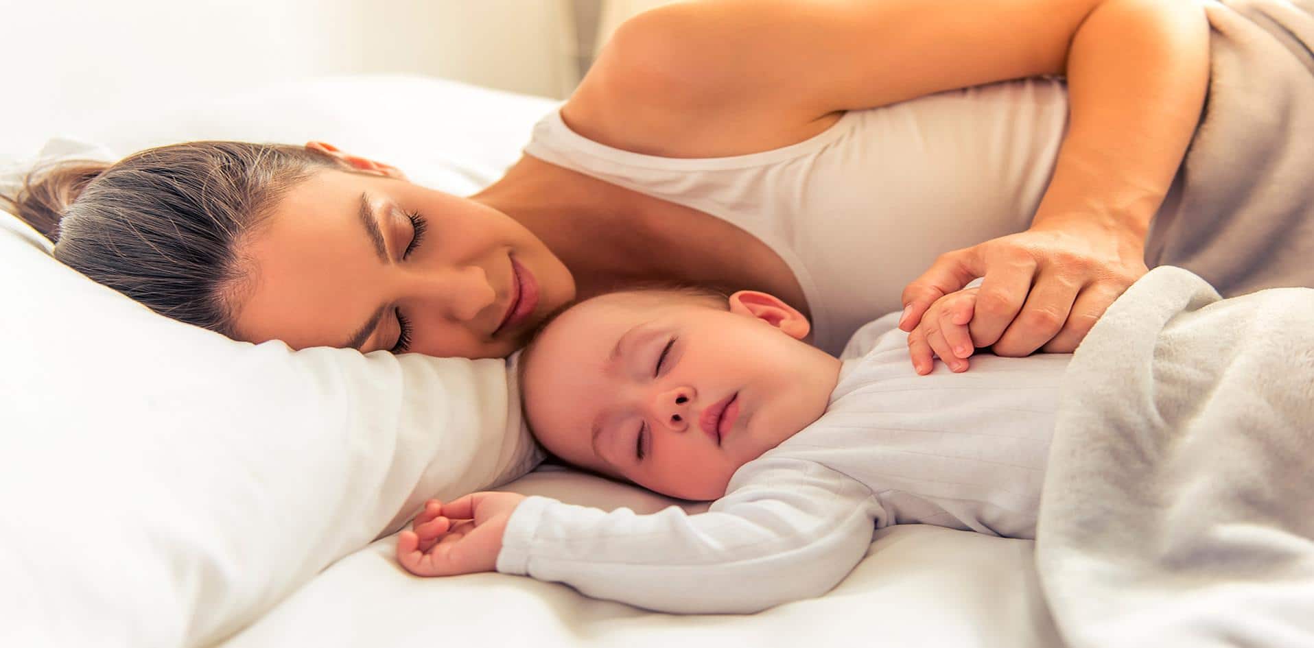 Mãe dormindo com bebê em cama compartilhada