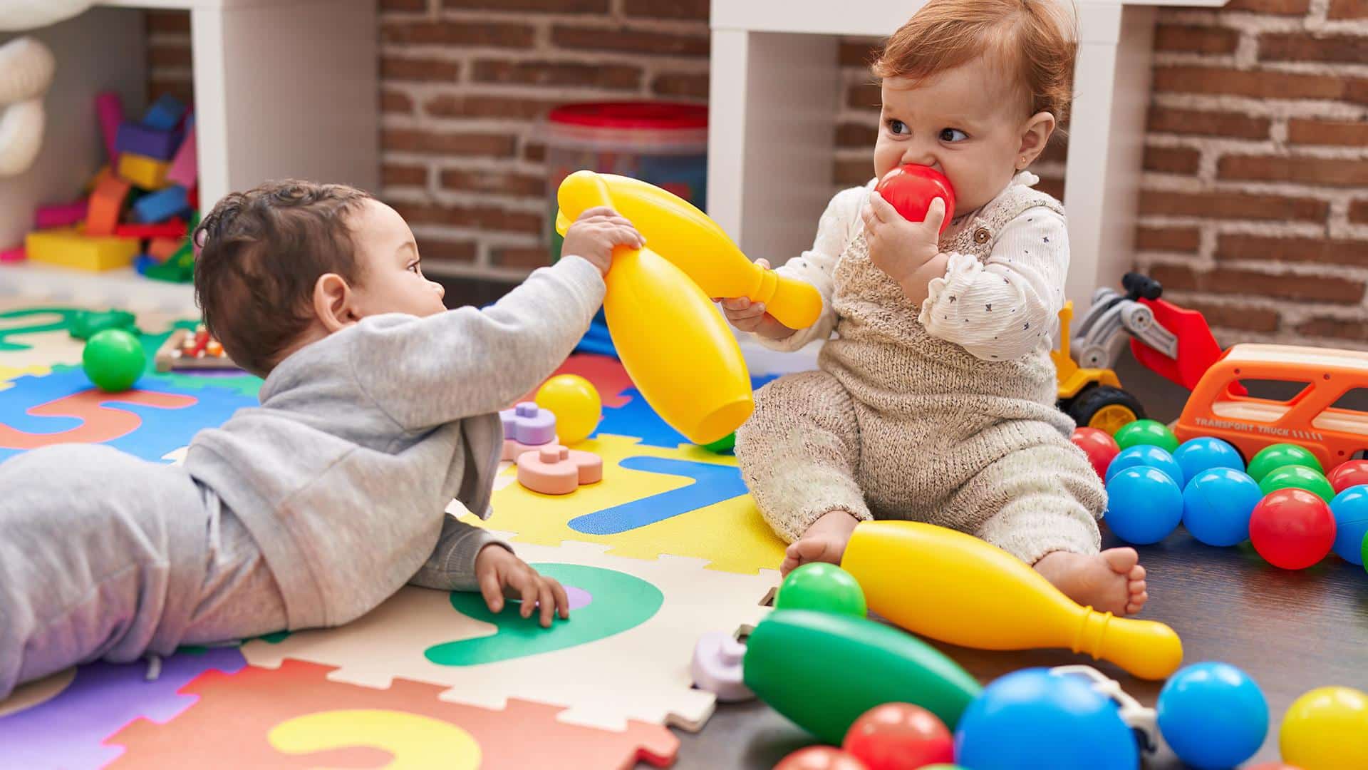 Bebê levando brinquedo à boca