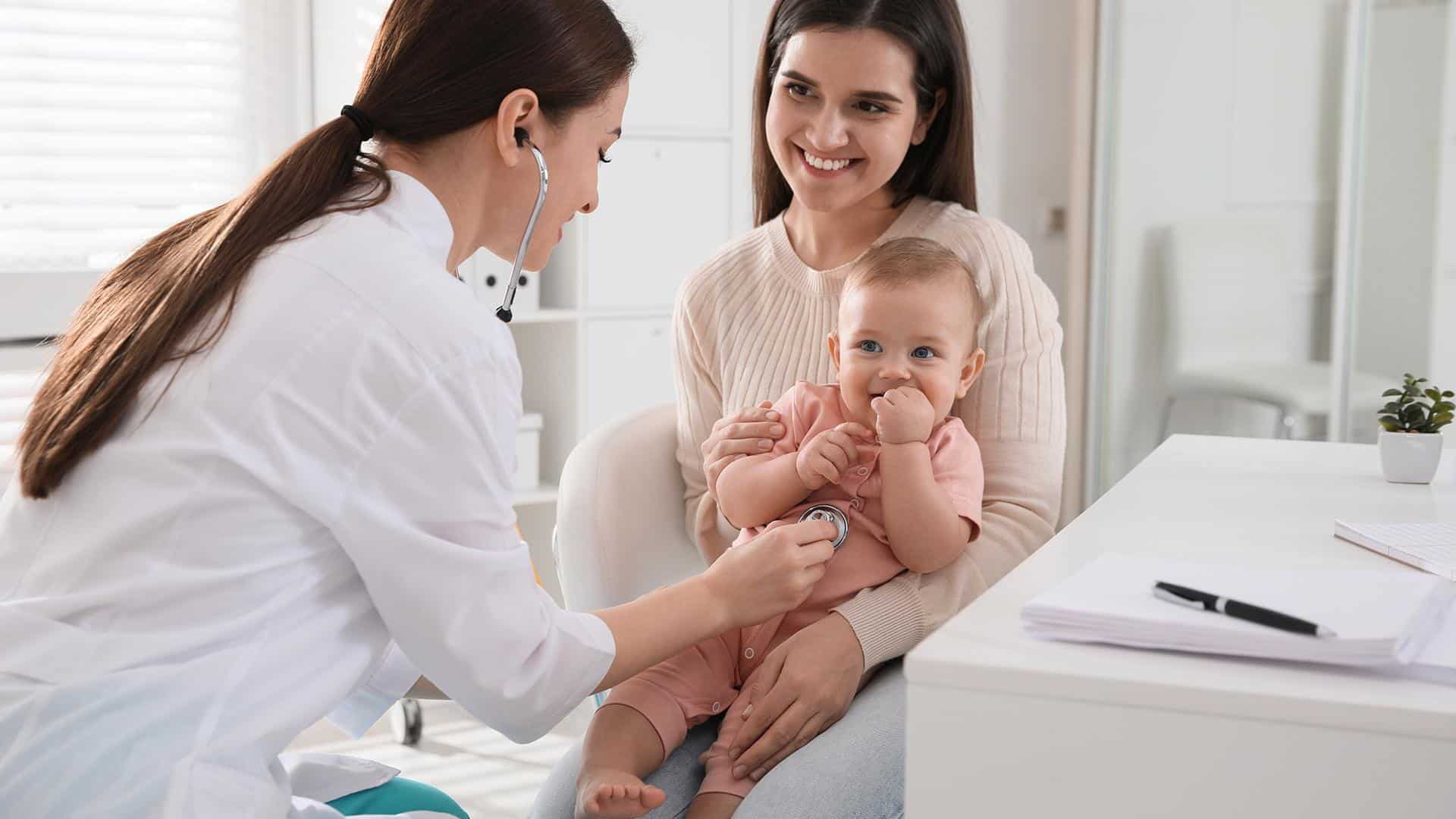 Consulta pediátrica com um pequeno risonho